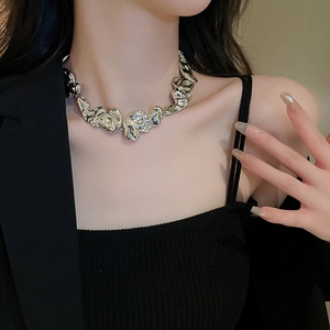 Detail of silver irregular lava style necklace on model for a minimalist luxury look