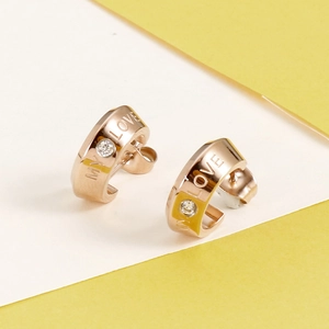 Detailed view of rose gold C-shaped earrings with MY LOVE engraving and small zircon stone