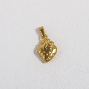 Macro shot of 24K gold plated stainless steel strawberry pendant with textured finish