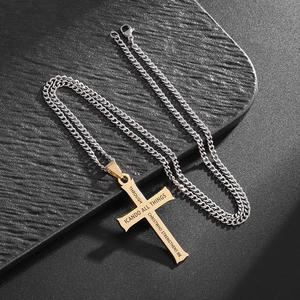 Detail of gold cross pendant with engraved scripture on a silver chain over black leather