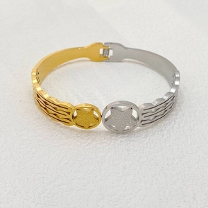 Macro detail of two-tone stainless steel star bracelet with polished gold and silver finish