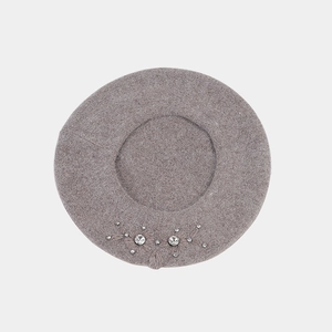 Detailed close-up of rhinestone floral embellishment on taupe wool knit beret hat