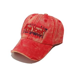 Detail of red vintage washed canvas baseball cap with 3D New York embroidery text