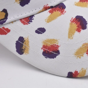 Macro view of cotton baseball cap brim with colorful oil paint splatter print and neat stitching