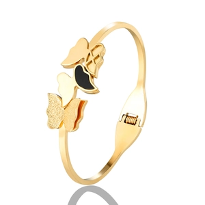 Detail of butterfly gold bangle featuring black enamel, frosted and hollow wing designs