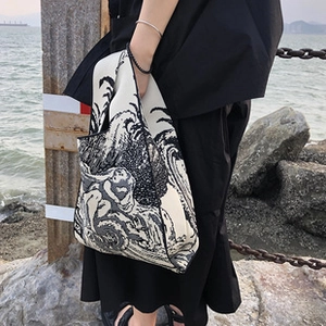 Detail of knitted tote bag featuring a traditional black and white Japanese wave pattern
