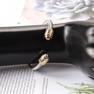 Close-up of titanium steel twisted cable bangle with grid pattern ball ends on display
