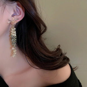 Detail of elegant gold bow tassel earrings with crystals on a model for a stylish look