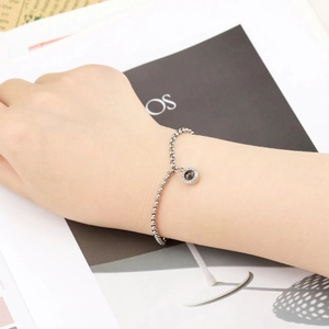 Macro detail of silver circle projection bracelet with zirconia inlay on female wrist