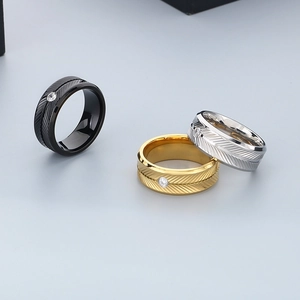 Detailed close-up of stainless steel feather pattern rings with zircon in black, gold, and silver