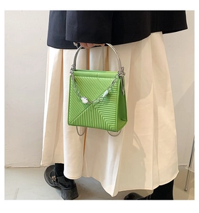 Green leather tote bag with V-shaped stitching and decorative pearl chain detail