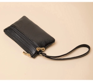 Detail of double zipper mini coin purse in black lychee texture with gold hardware