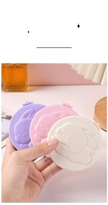 Handheld view of a compact folding round makeup mirror with a cute 3D bunny relief