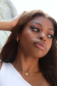 Model wearing 18K gold sun-style micro-set zircon earrings and wavy square necklace