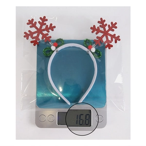 Detail shot showing the 16.8g weight of the red glitter snowflake Christmas headband