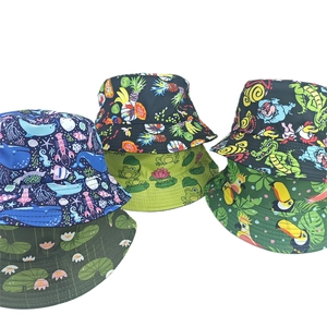 Flat lay of multiple reversible bucket hats with fruit and animal prints on white background