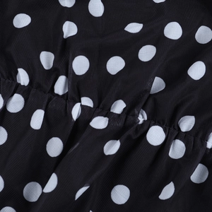 Detail aus schwarzem Netzstoff mit weißen Punkten, weichen Falten und Textur