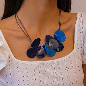 Close-up of blue acrylic flower pendant on double-strand brown cord necklace