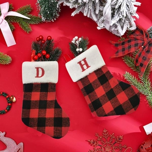 Red and black plaid Christmas stocking with white plush trim and embroidered red letter D