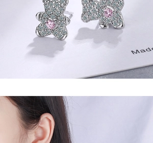 Detailed view of silver bear stud earrings with pink heart stone and white cubic zirconia