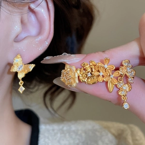 Macro shot of 24K gold plated flower earrings with cubic zirconia and matte texture