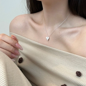 Detailed close-up of a s925 silver heart pendant necklace with hammered texture finish
