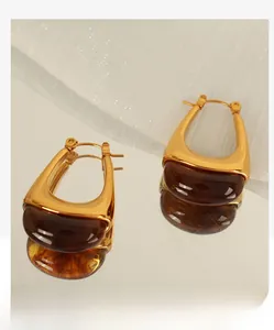 Detailed close-up of vintage golden drop earrings with translucent amber-tone resin stones