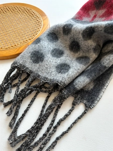 Close-up of thick grey pashmina scarf with black polka dots and red color blocking