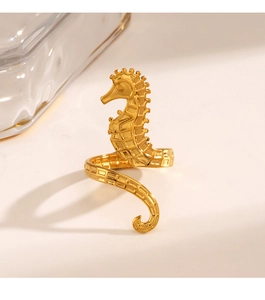 Detailed close-up of a 3D seahorse-shaped golden ring with intricate scale textures