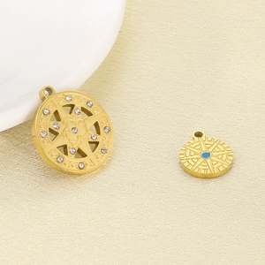 Detail of gold compass and star pendants with white diamonds on textured cloth