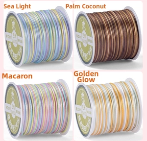 Detailed view of four colorful braided cords wound on white plastic spools for DIY jewelry