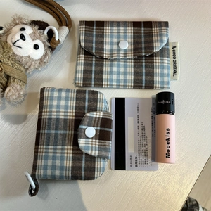 Detail of vintage plaid card holder with button closure and multi-layer storage compartments