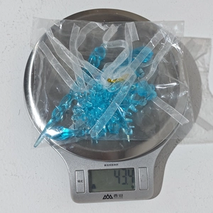 Detailed view of 5pcs clear acrylic snowflake ornaments on a scale for weight display