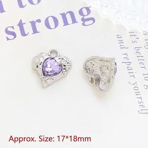 Macro shot of 17x18mm silver heart pendants with purple gems and textured reverse