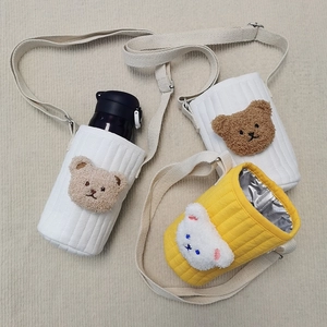 Detailed view of quilted bear bottle bags with adjustable shoulder straps and plush charms