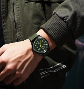 Close-up of military quartz watch with olive green nylon strap and 50M water resistance