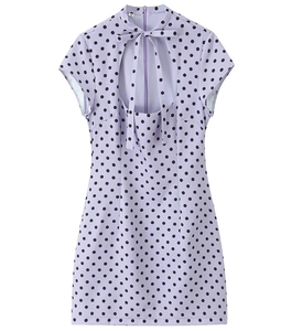 Detailed view of the bow neckline and hollow-out chest design on a polka dot dress