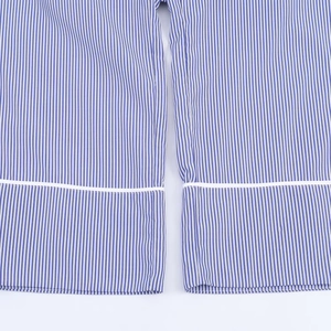Détail des poignets de chemise à rayures verticales bleues et blanches avec bord blanc
