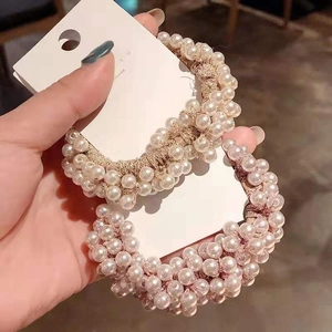 Set of two handmade pearl elastic hair ties shown on a display card in hand
