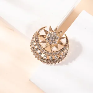 Detailed close-up of a gold star and moon brooch with sparkling cubic zirconia crystals