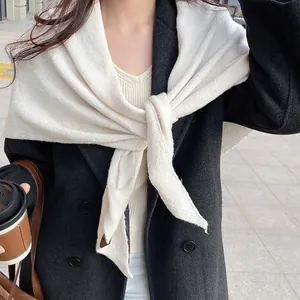 Châle en tricot blanc crème rétro avec un manteau en laine noir pour un look d'automne chic