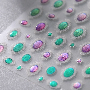 3D embossed nail art stickers with turquoise gems and white lace patterns on silver glitter