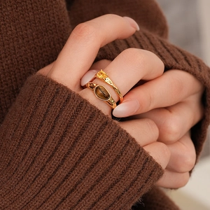 Detail of 18k gold plated tiger eye stone rings on hand with vintage textured design