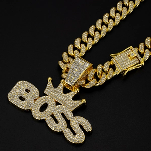 Detail shot of iced out gold BOSS pendant with crown on sparkling cuban link chain