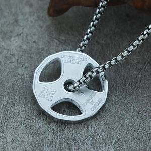 Macro detail of silver dumbbell pendant necklace with engraved workout motivational quotes