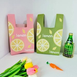 Close-up of strawberry knit tote bags with lemon pattern and textured cotton weave