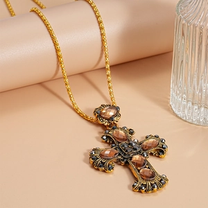 Macro detail of vintage cross pendant with brown crystals and black rhinestones