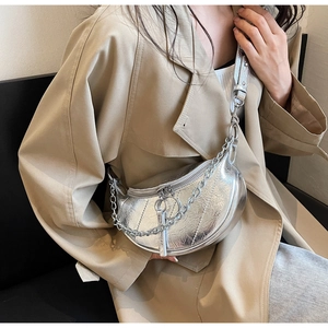 Detail of silver metallic crescent bag with chunky chain strap and pleated texture
