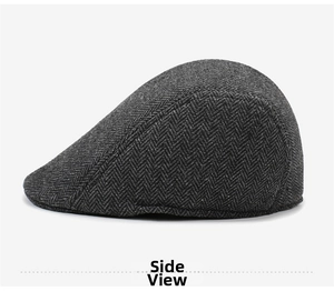Detailed side view of dark grey herringbone texture on a vintage flat cap
