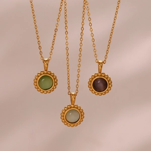 Detailed view of sun-themed vintage gold necklaces with green, grey, and purple stones